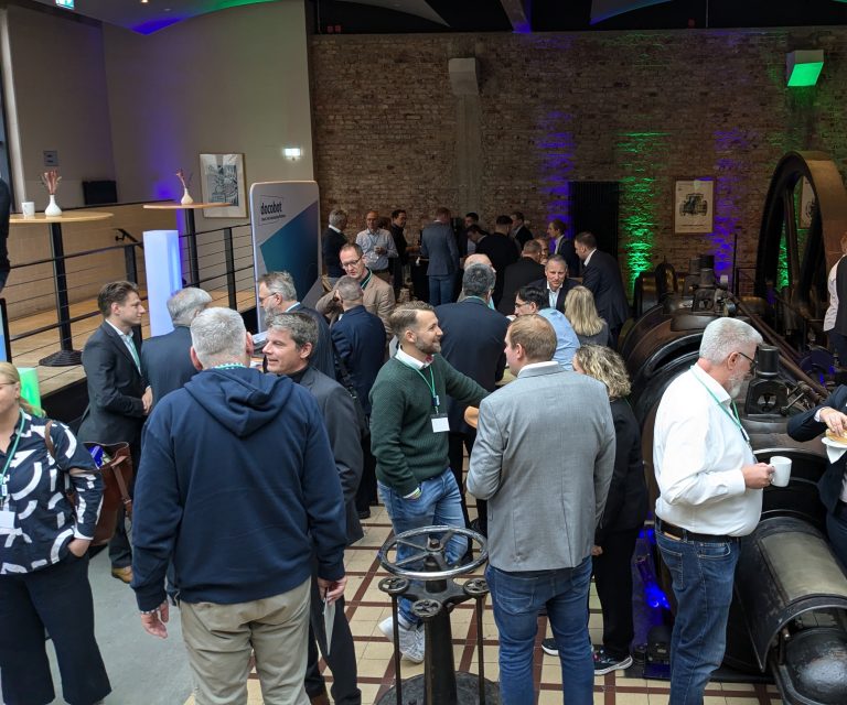 Menschen, die sich in einer Industrieumgebung während einer Veranstaltung unterhalten und interagieren.