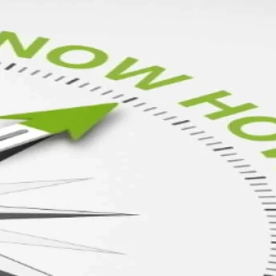 Kompass mit einem grünen Pfeil und dem Schriftzug 'Know How' in grauer Schrift.